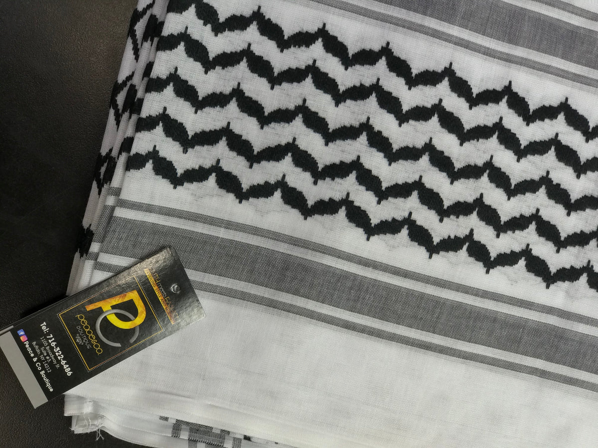 Traditional black and white keffiyeh scarf showing patterned fabric and fringe.