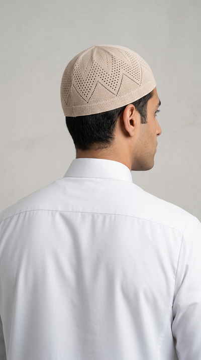 Man wearing a cream topi prayer cap, rear view