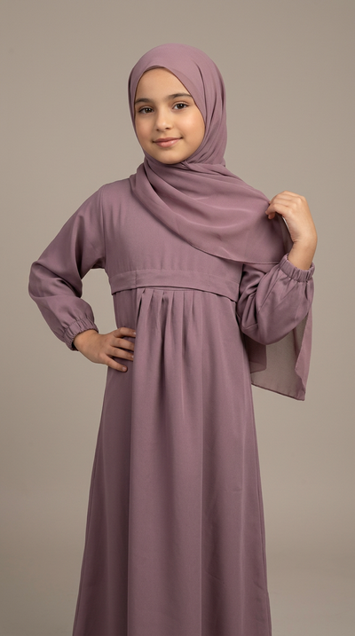 Purple girls' abaya showing practical front pocket styling.