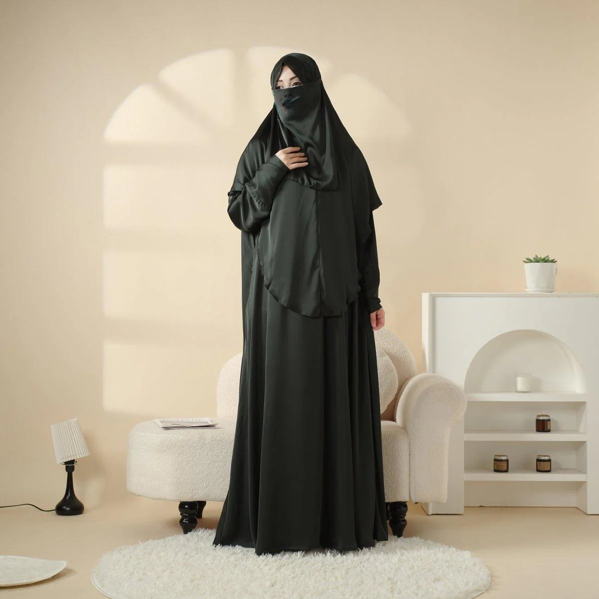 Woman wearing a black abaya in a modern living room setting