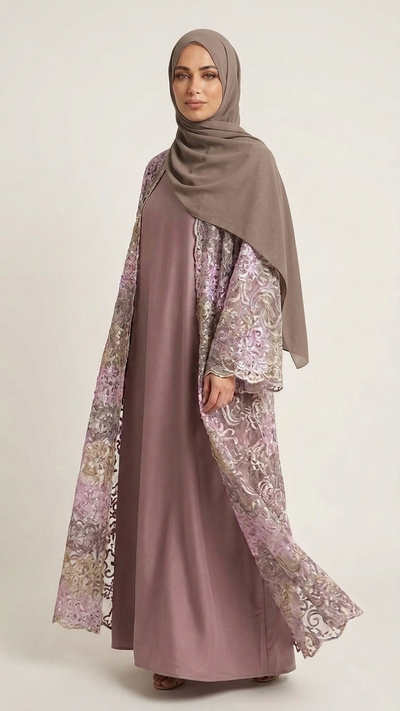 A woman wearing a modest outfit consisting of a dusty mauve abaya with intricate lavender and gold floral lace sleeves, a matching dusty mauve hijab, and brown flat shoes, photographed against a solid light beige background.