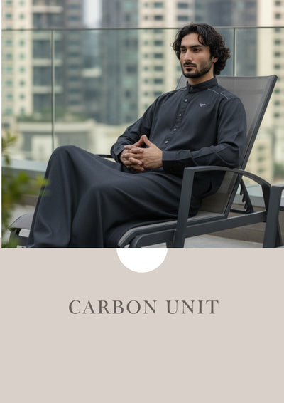 Man sitting on a chair with a cityscape background, wearing a black outfit.