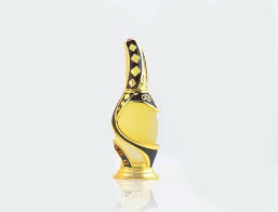 A perfume bottle with a golden hue and intricate designs on the top, set against a white background.
