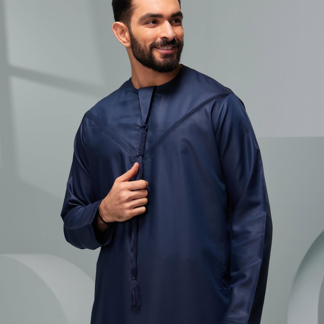 Man wearing a navy blue long-sleeve shirt against a gray background